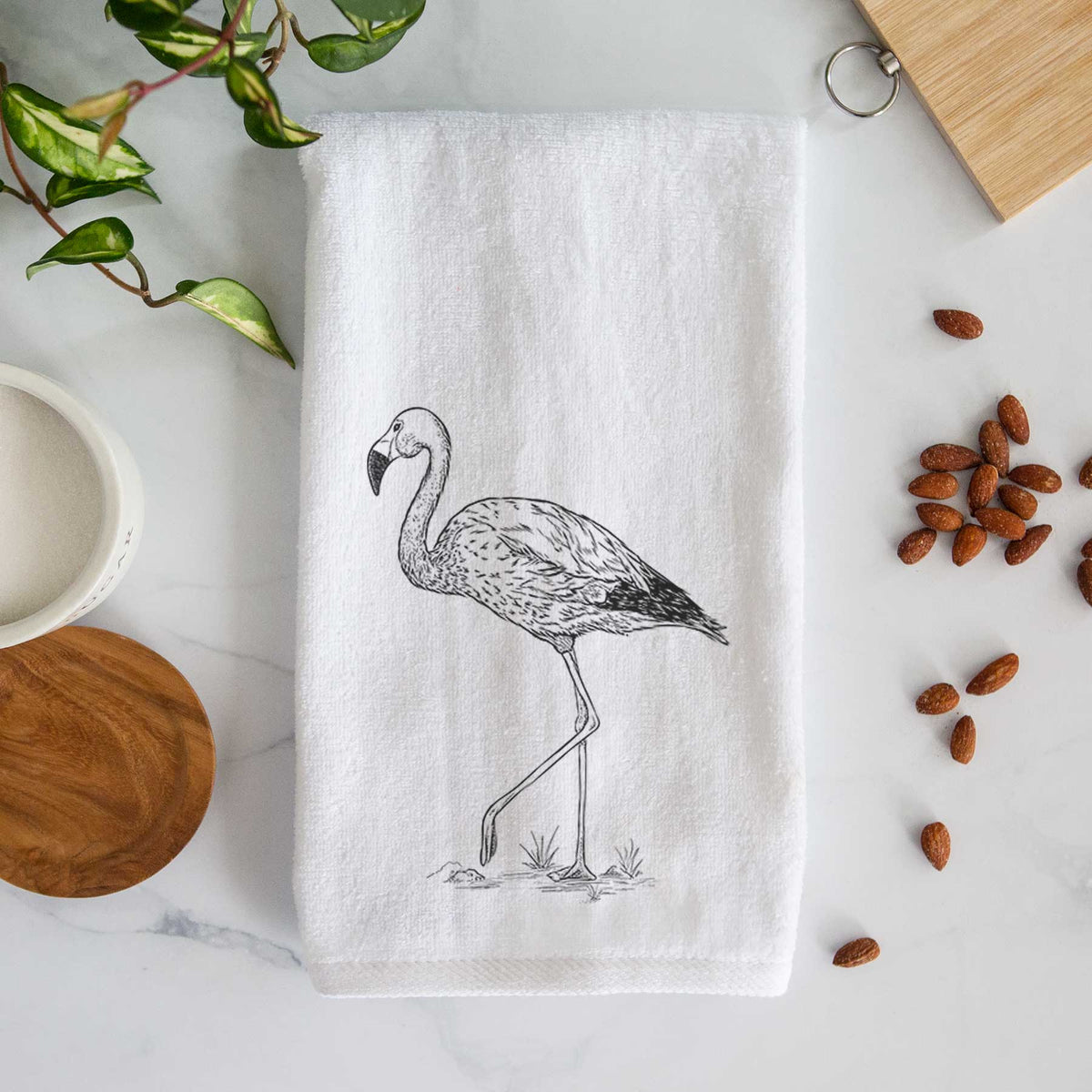 White hand towel printed with a black ink illustration of an Andean flamingo standing on one leg.