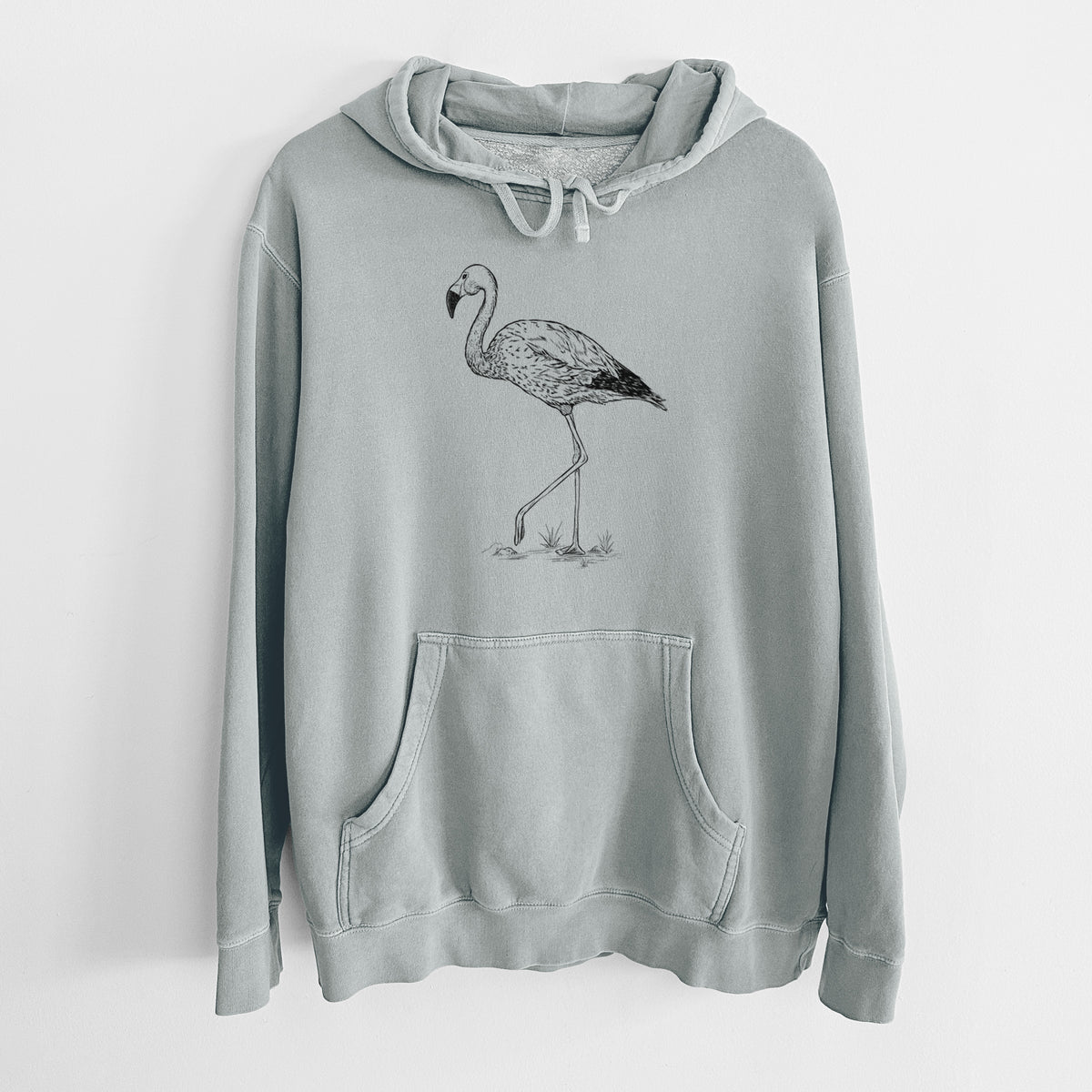 Sage green pigment dyed hoodie laid flat, printed with a black ink illustration of an Andean flamingo standing on one leg.