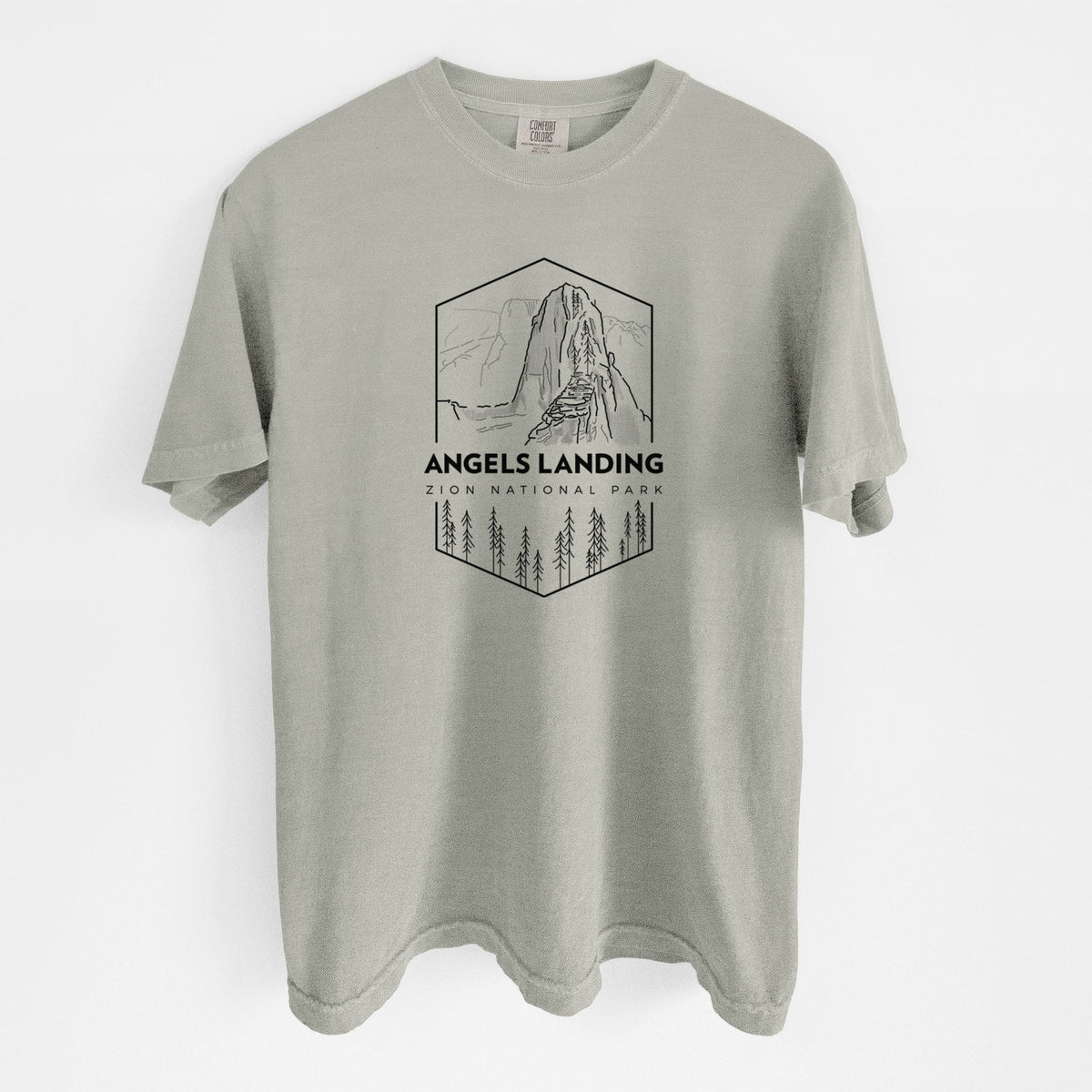Sandstone beige Comfort Colors t-shirt laid flat, printed with a black line art badge of Angels Landing above pine trees, with the words Angels Landing, Zion National Park.