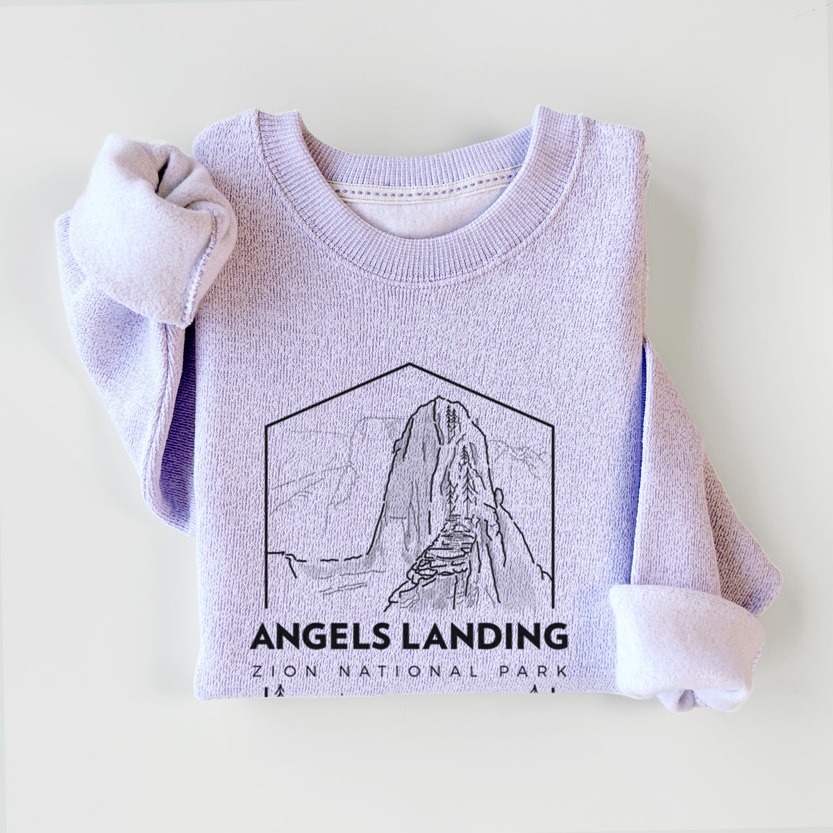 Ice purple knit sweatshirt printed with a black line art badge of Angels Landing above pine trees, with the words Angels Landing, Zion National Park, styled flat.