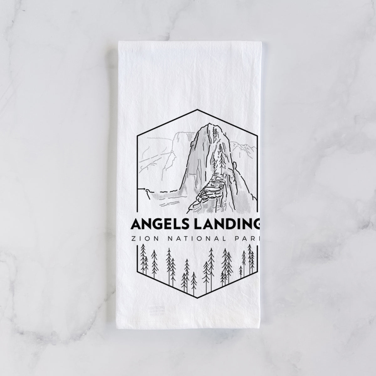 White cotton tea towel laid flat on marble, printed with a black line art badge of Angels Landing above pine trees, with the words Angels Landing, Zion National Park.