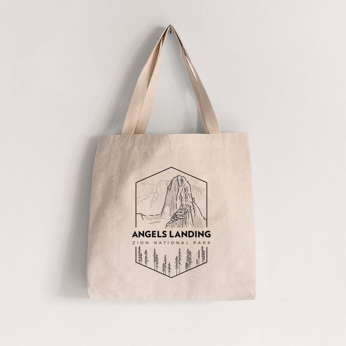 Natural canvas tote bag printed with a black line art badge of Angels Landing above pine trees, with the words Angels Landing, Zion National Park.