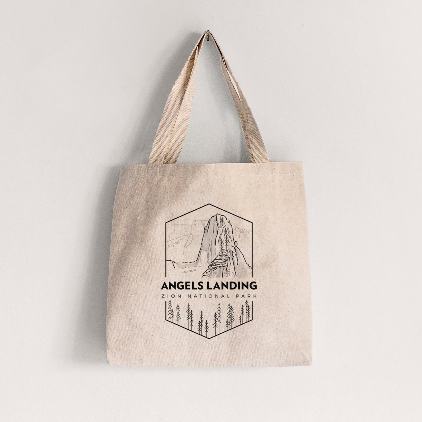Natural canvas tote bag printed with a black line art badge of Angels Landing above pine trees, with the words Angels Landing, Zion National Park.