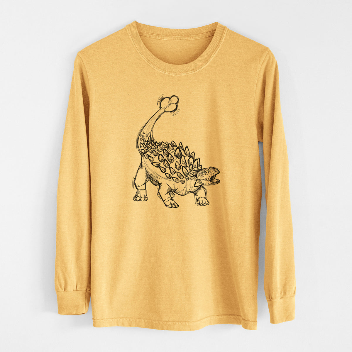 Golden wheat yellow Comfort Colors long sleeve shirt laid flat, printed with a black ink illustration of an Ankylosaurus with its club tail raised.