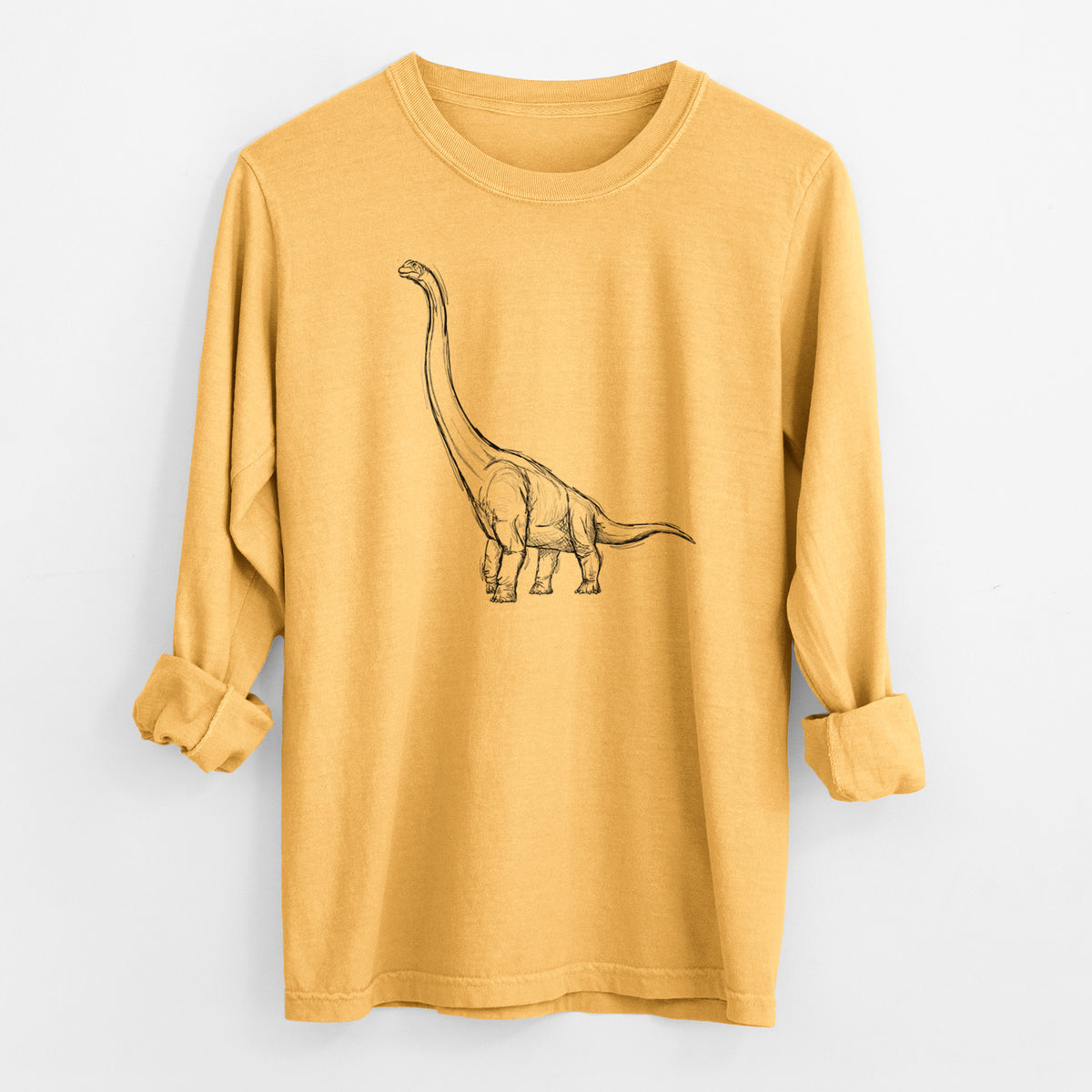 Golden wheat yellow Comfort Colors long sleeve shirt laid flat with the cuffs rolled, printed with a black ink illustration of a long-necked Apatosaurus walking.