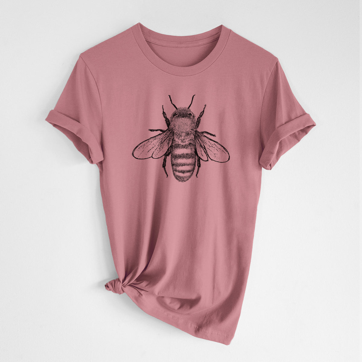 Mauve pink lightweight cotton t-shirt laid flat with the sleeves rolled, printed with a detailed black ink illustration of a honey bee with its wings spread, seen from above.