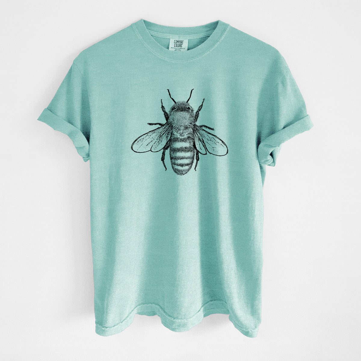 Chalky mint Comfort Colors t-shirt laid flat, printed with a detailed black ink illustration of a honey bee with its wings spread, seen from above.