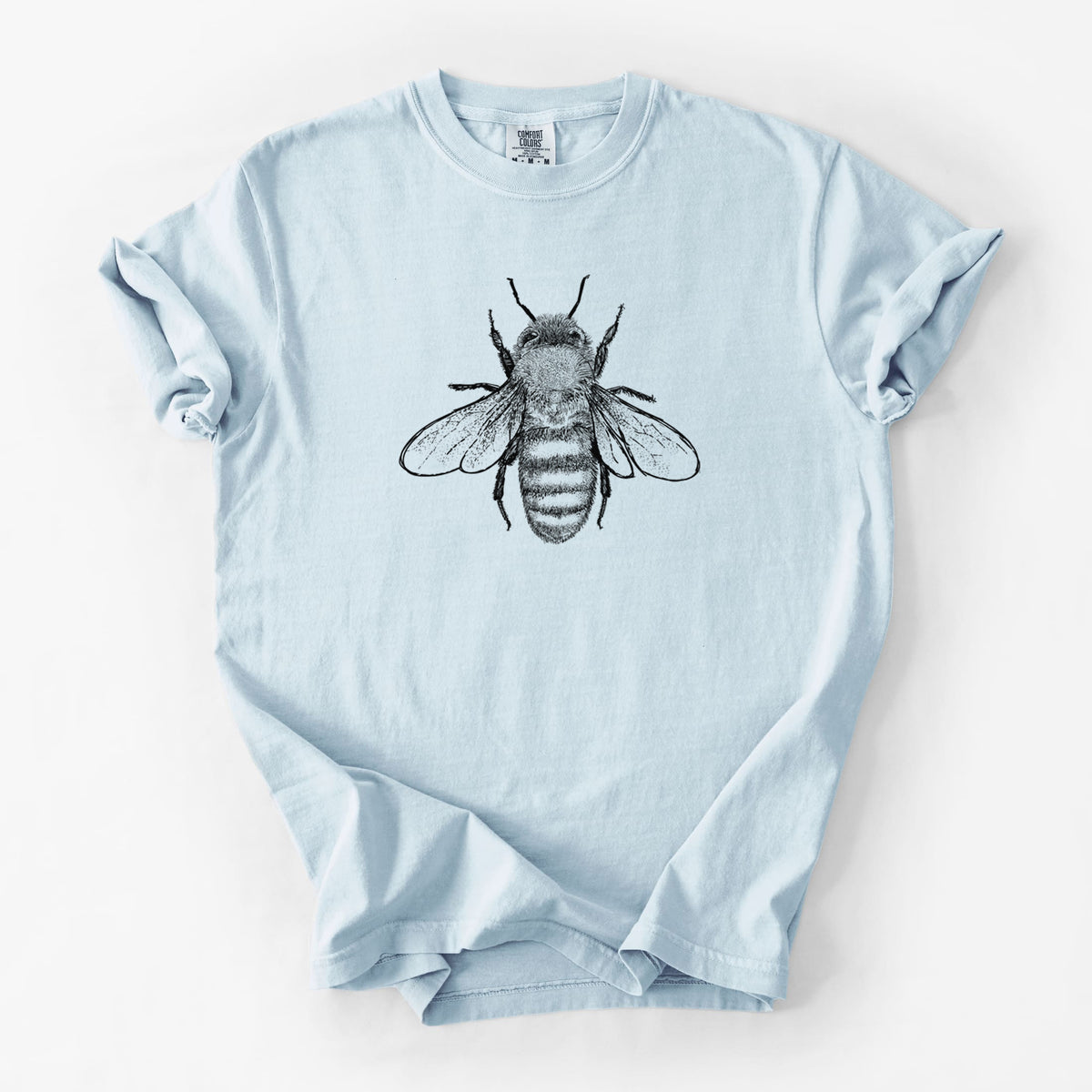 Chambray blue Comfort Colors t-shirt laid flat, printed with a detailed black ink illustration of a honey bee with its wings spread, seen from above.