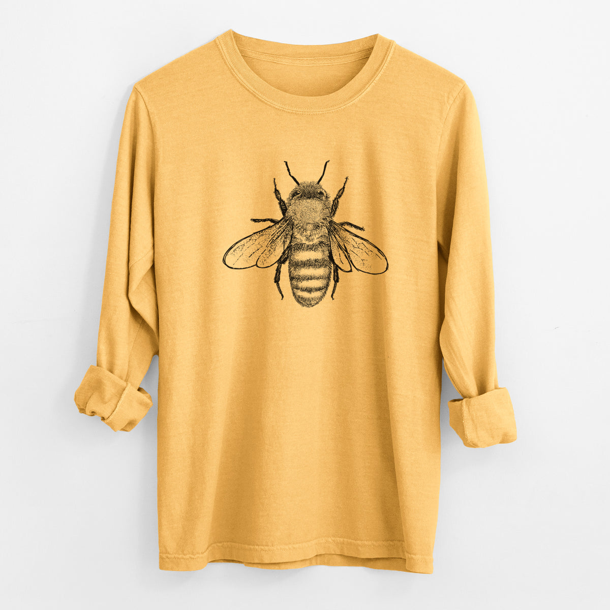 Golden wheat yellow Comfort Colors long sleeve shirt laid flat with the cuffs rolled, printed with a detailed black ink illustration of a honey bee with its wings spread, seen from above.