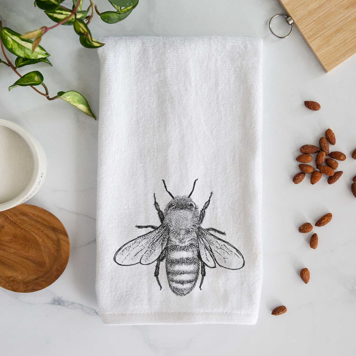 White hand towel printed with a detailed black ink illustration of a honey bee with its wings spread, seen from above.