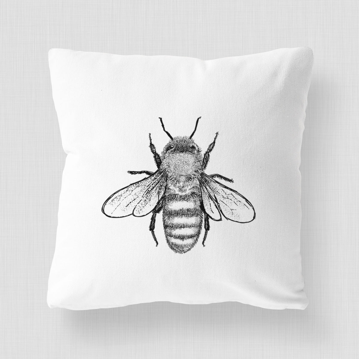 White pillow cover printed with a detailed black ink illustration of a honey bee with its wings spread, seen from above.