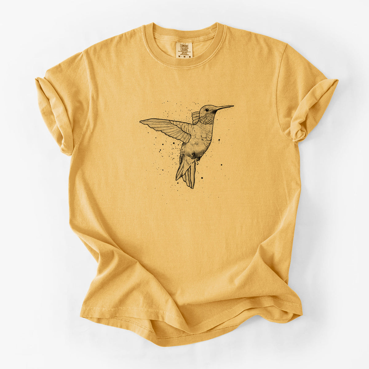 Golden wheat yellow Comfort Colors t-shirt laid flat, printed with a black ink sketch of a ruby-throated hummingbird hovering with its wings raised.