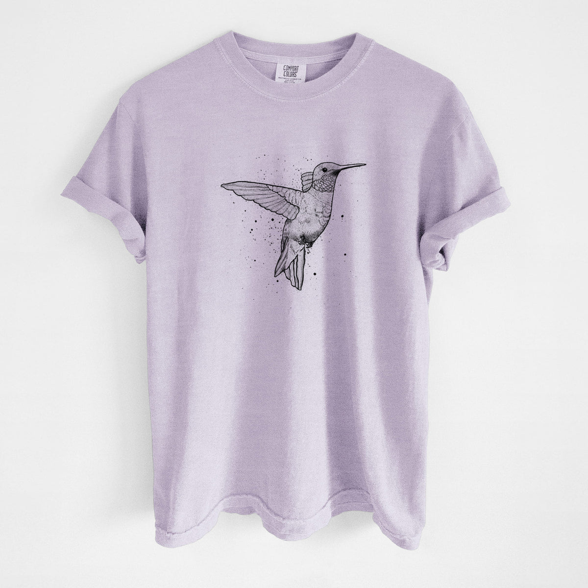 Orchid purple Comfort Colors t-shirt laid flat, printed with a black ink sketch of a ruby-throated hummingbird hovering with its wings raised.