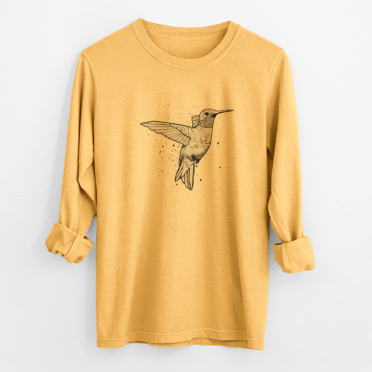 Golden wheat yellow Comfort Colors long sleeve shirt laid flat with the cuffs rolled, printed with a black ink sketch of a ruby-throated hummingbird hovering with its wings raised.