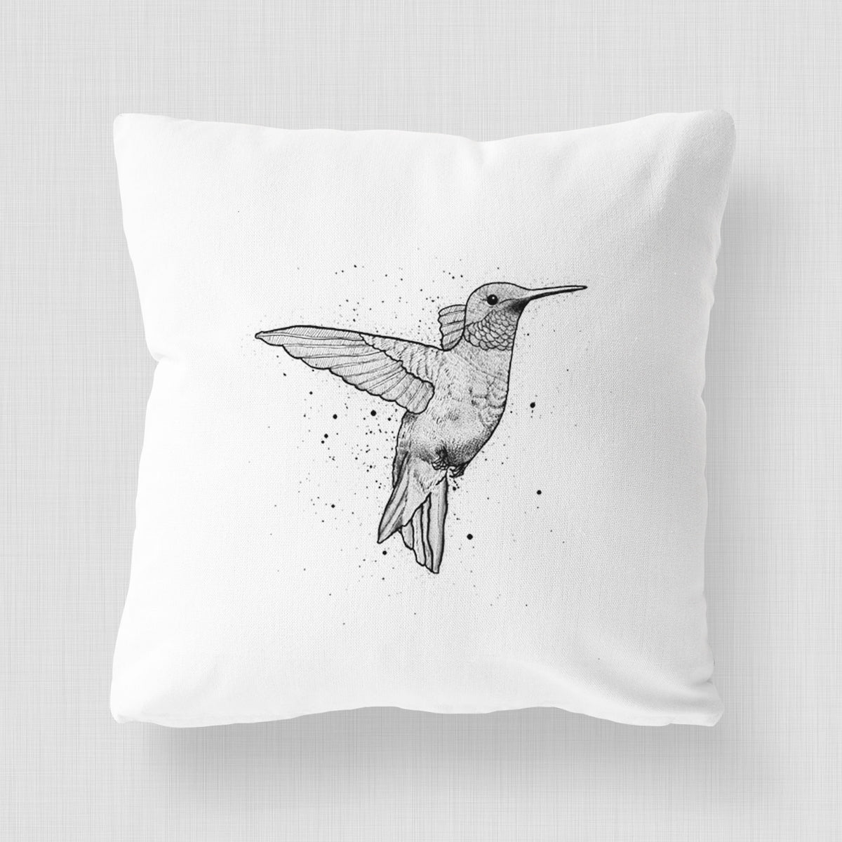 White pillow cover printed with a black ink sketch of a ruby-throated hummingbird hovering with its wings raised.
