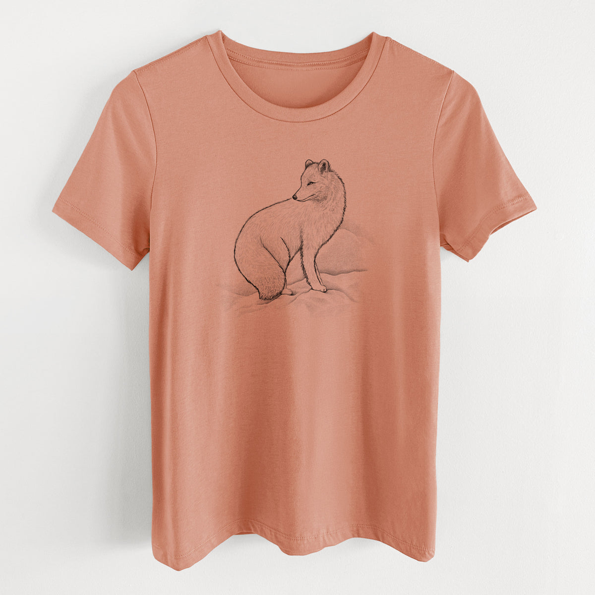 Terracotta orange women's relaxed fit cotton t-shirt laid flat, printed with a black ink illustration of an arctic fox sitting in the snow.