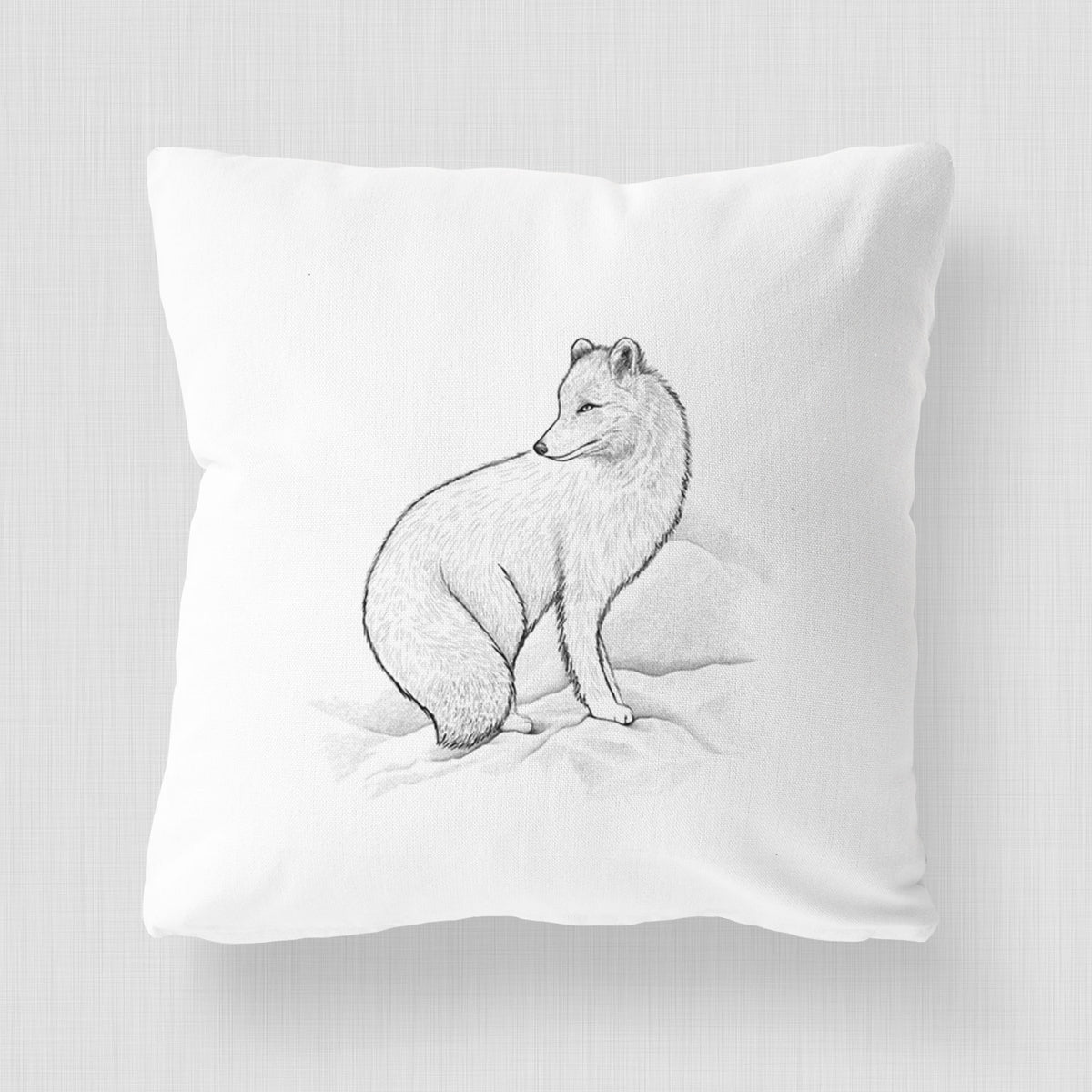 White pillow cover printed with a black ink illustration of an arctic fox sitting in the snow.