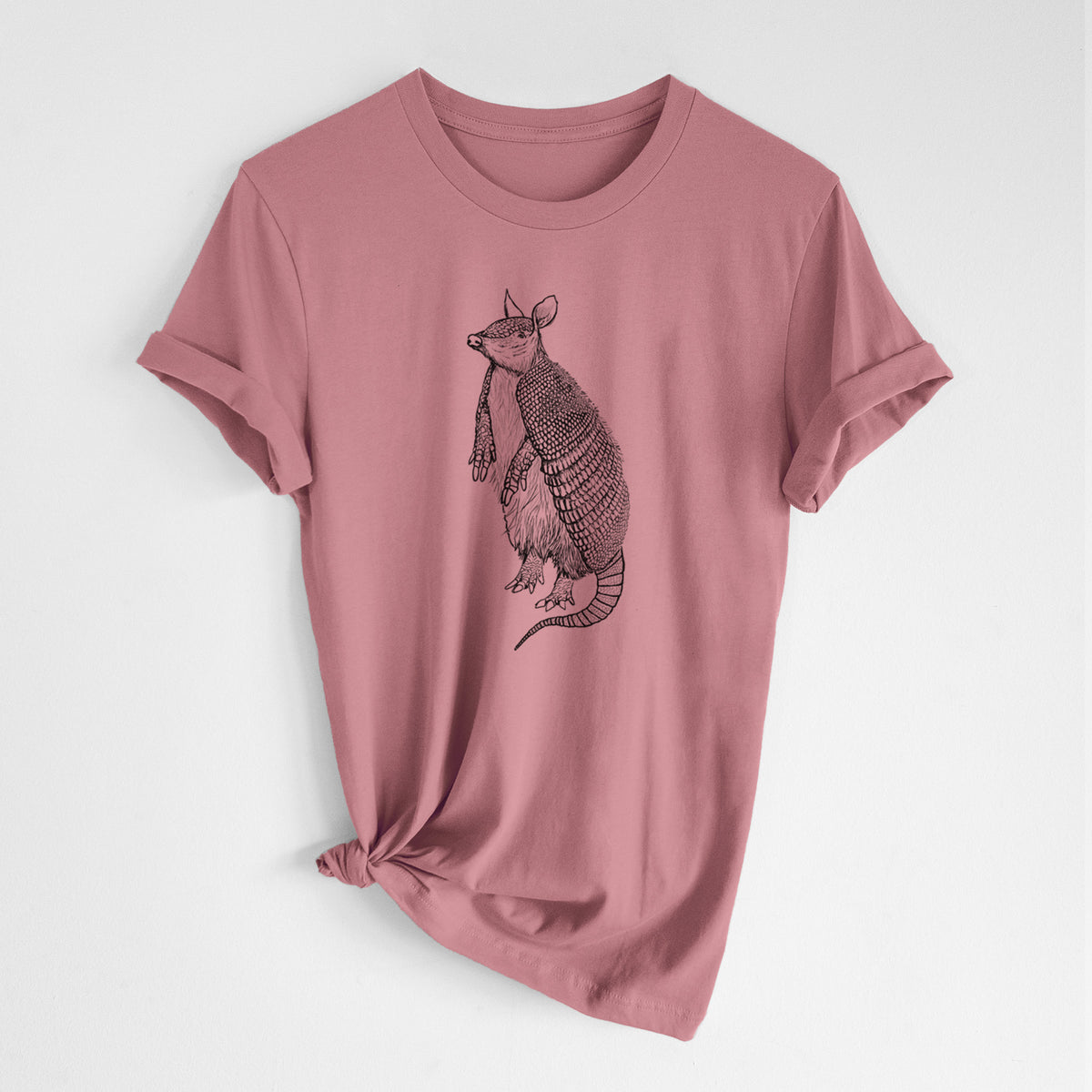 Mauve pink lightweight cotton t-shirt laid flat with the sleeves rolled, printed with a black ink illustration of a nine-banded armadillo standing upright.
