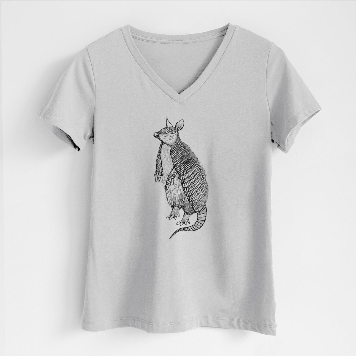 Lunar grey women's relaxed fit cotton V-neck t-shirt laid flat, printed with a black ink illustration of a nine-banded armadillo standing upright.