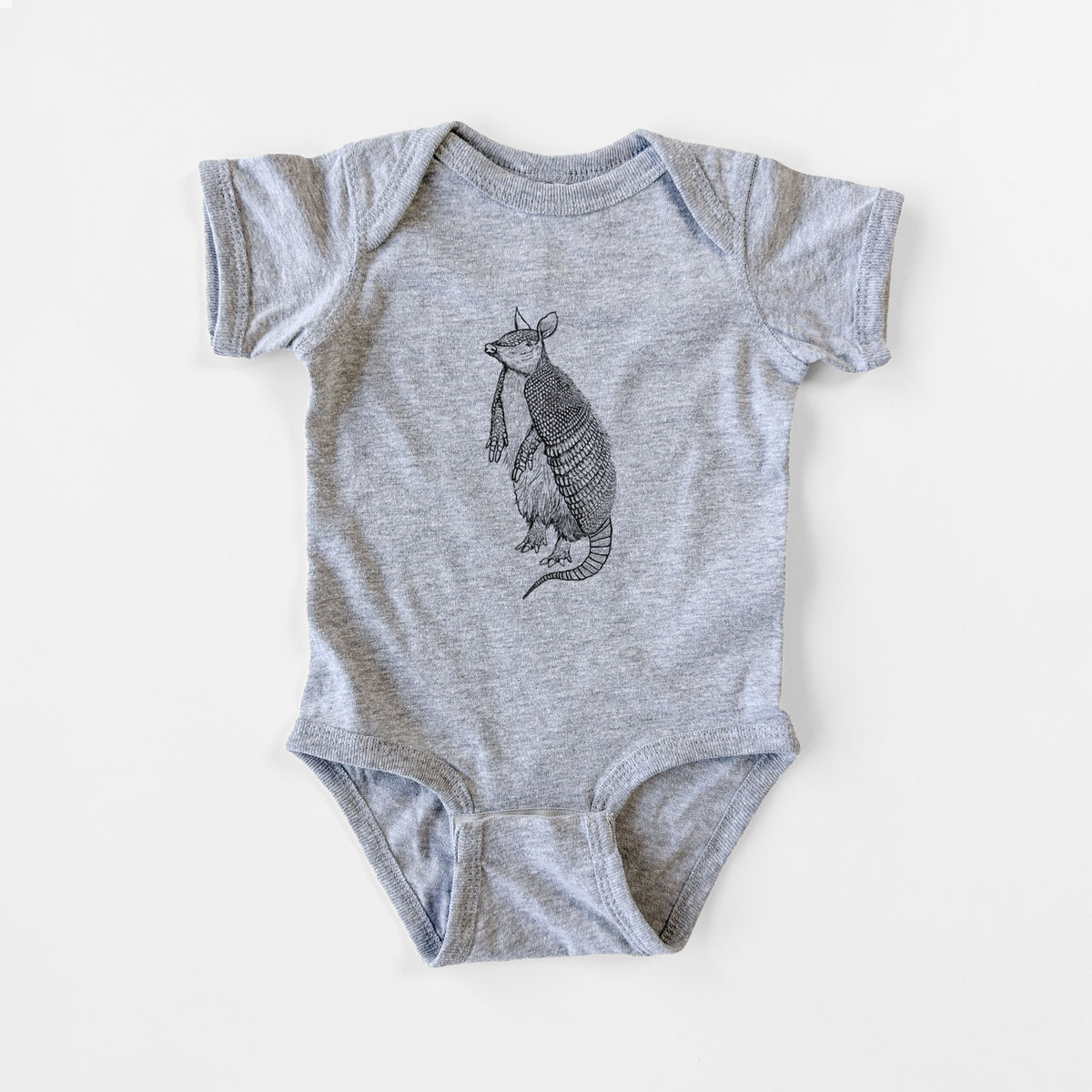Grey baby bodysuit laid flat, printed with a black ink illustration of a nine-banded armadillo standing upright.