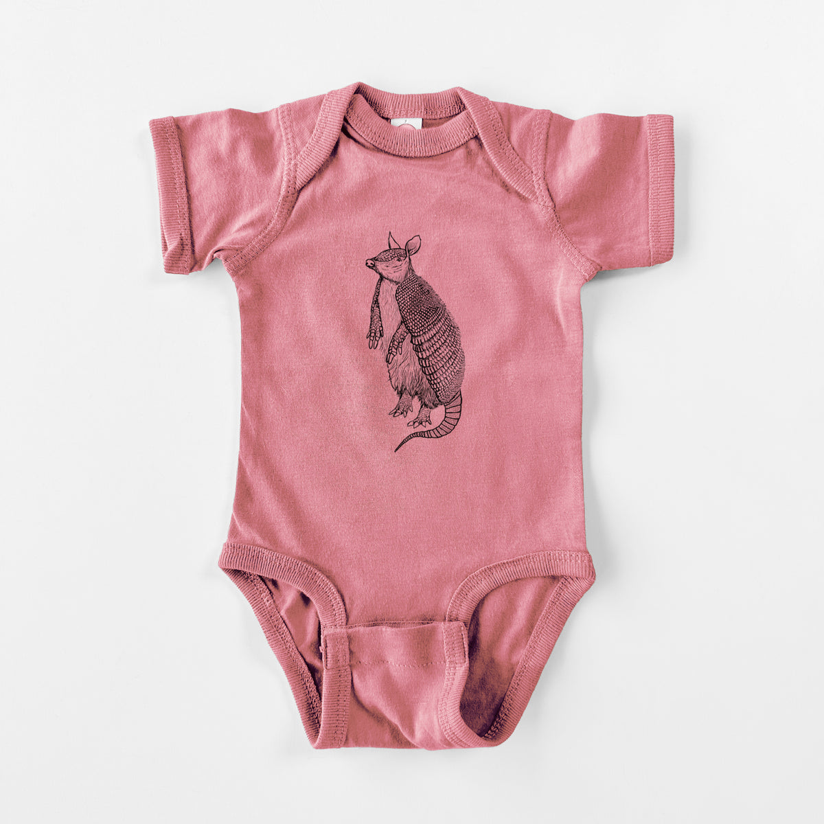 Mauve pink baby bodysuit laid flat, printed with a black ink illustration of a nine-banded armadillo standing upright.