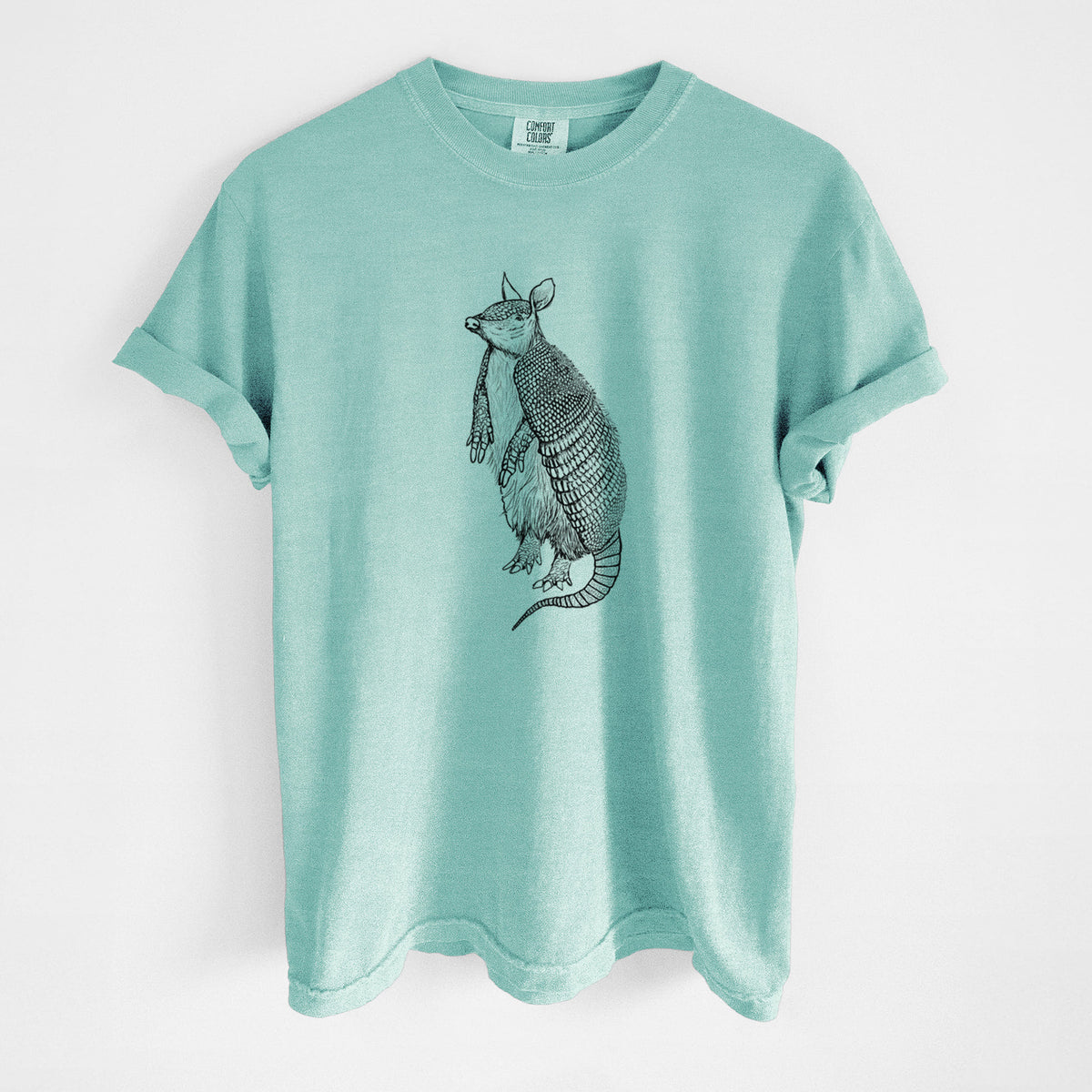Chalky mint Comfort Colors t-shirt laid flat, printed with a black ink illustration of a nine-banded armadillo standing upright.