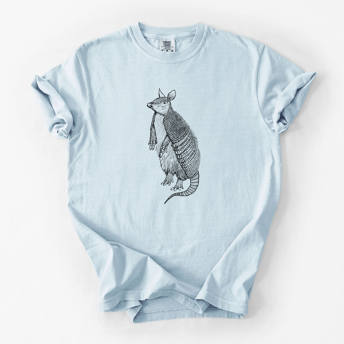 Chambray blue Comfort Colors t-shirt laid flat, printed with a black ink illustration of a nine-banded armadillo standing upright.