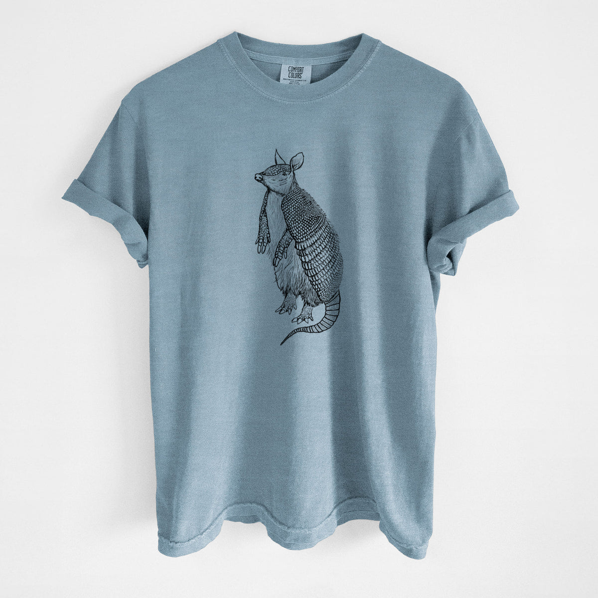 Steel blue Comfort Colors t-shirt laid flat, printed with a black ink illustration of a nine-banded armadillo standing upright.