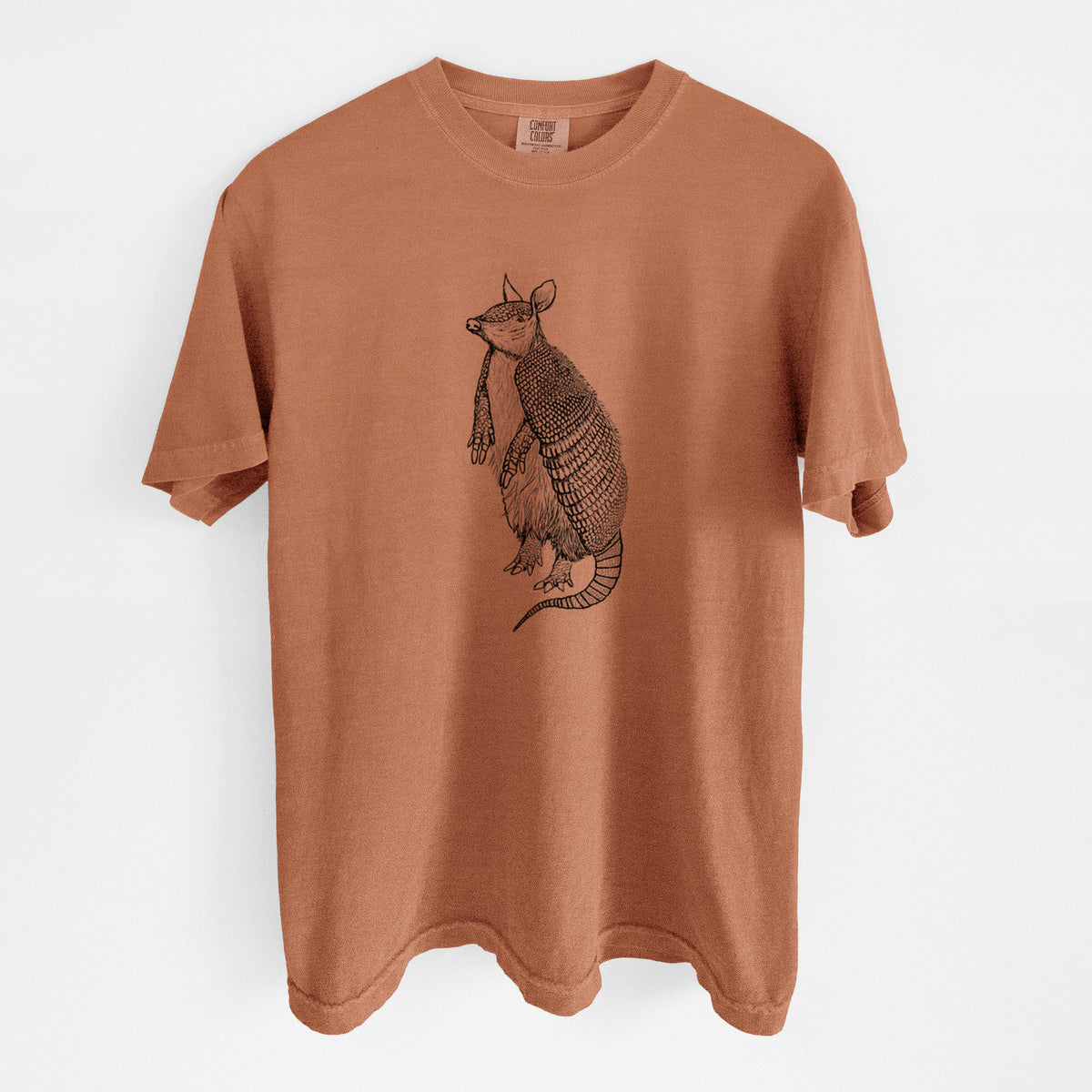 Yam burnt orange Comfort Colors t-shirt laid flat, printed with a black ink illustration of a nine-banded armadillo standing upright.