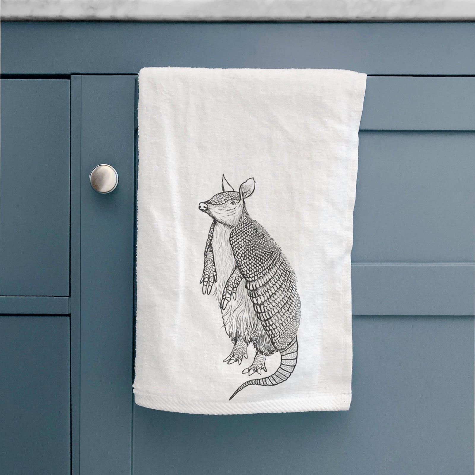White hand towel printed with a black ink illustration of a nine-banded armadillo standing upright.