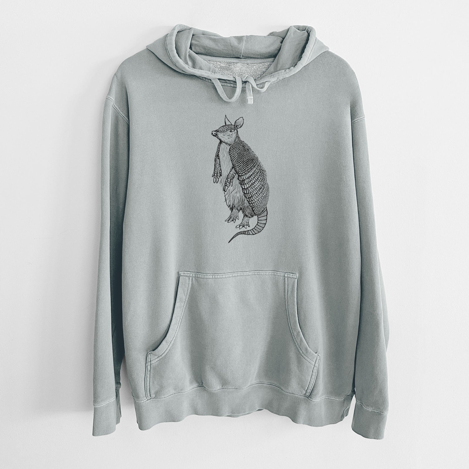 Sage green pigment dyed hoodie laid flat, printed with a black ink illustration of a nine-banded armadillo standing upright.