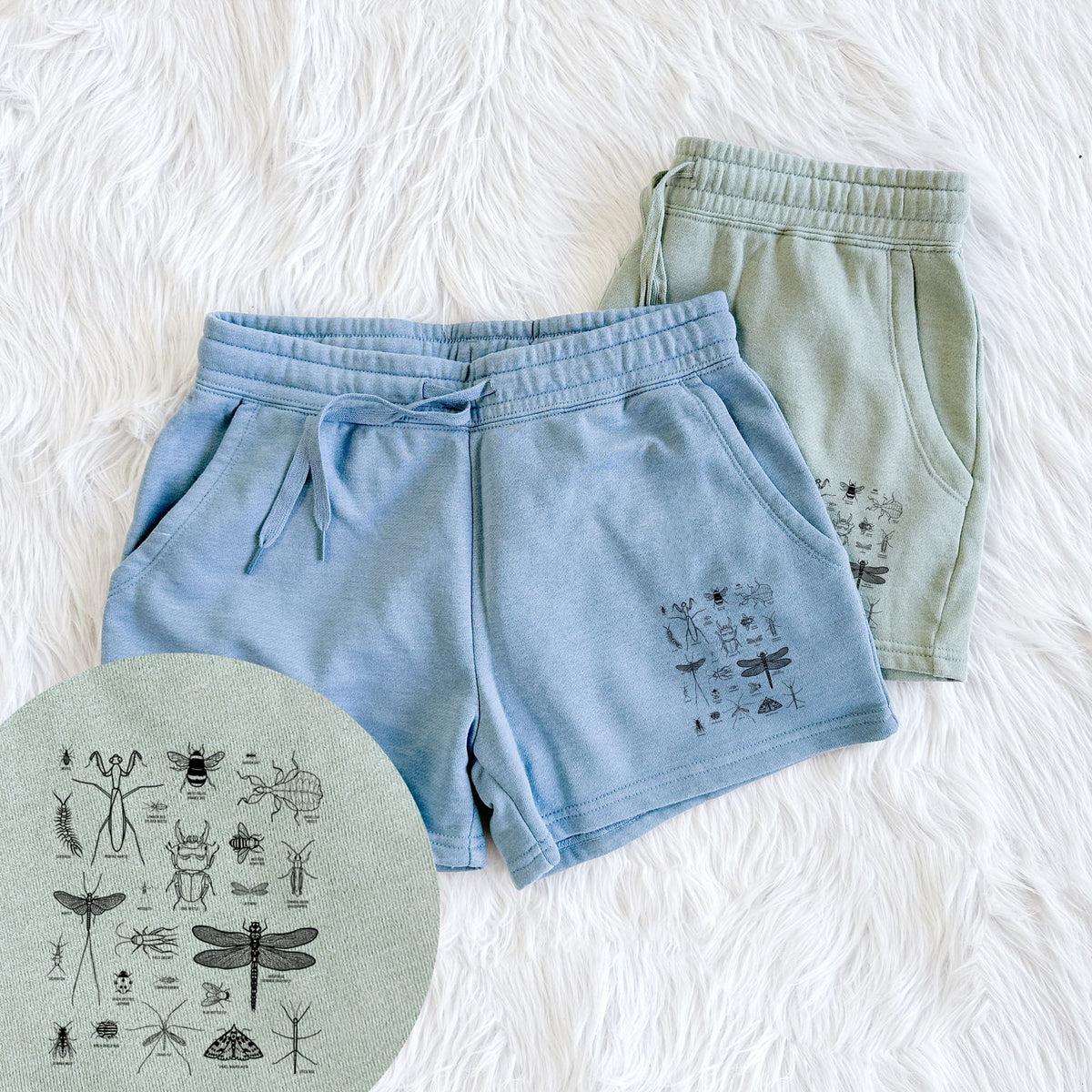 Two pairs of Cali Wave shorts in different colors printed with a chart of black ink insect and arthropod illustrations, including dragonflies, beetles, spiders and bees, with a close-up of the print.