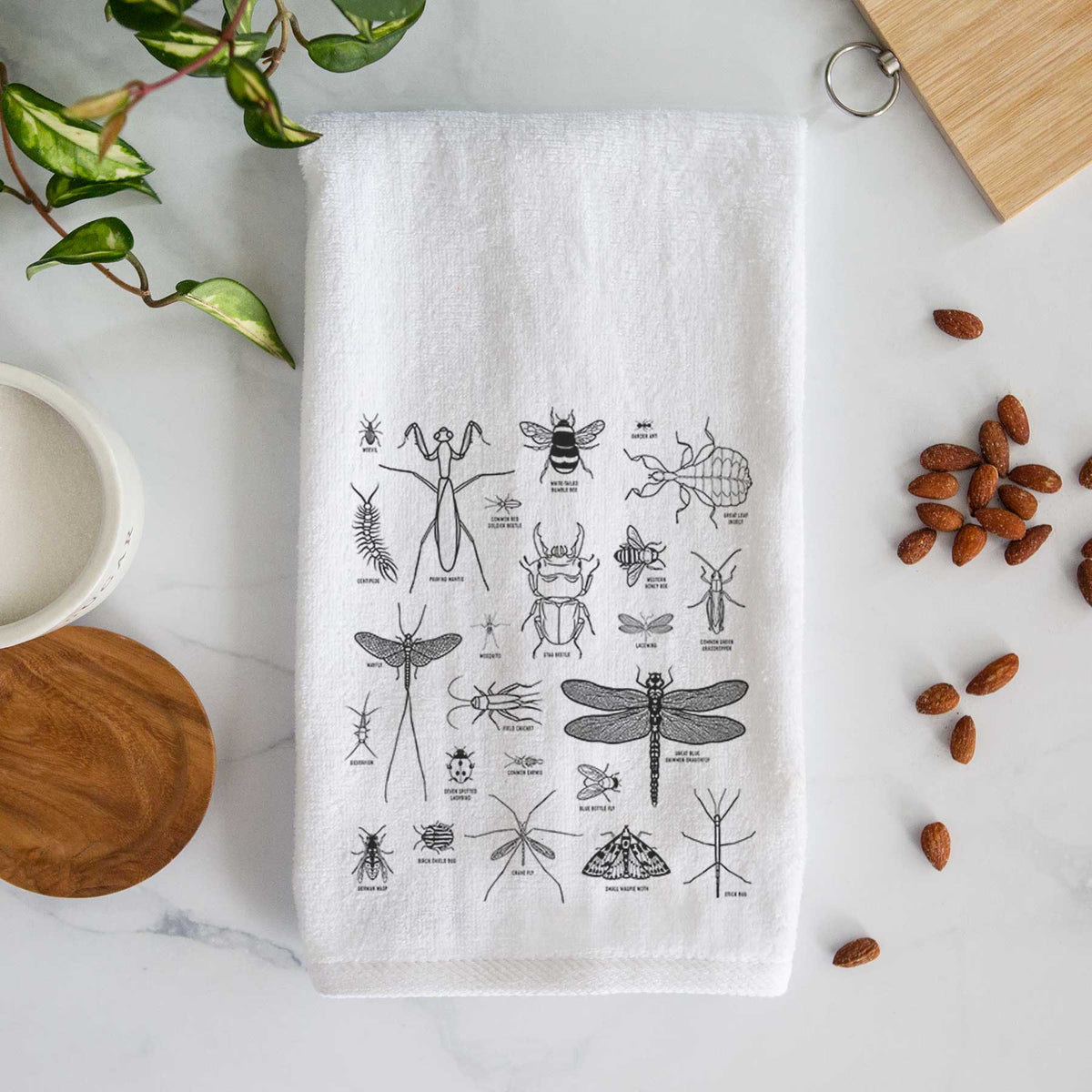 White hand towel printed with a chart of black ink insect and arthropod illustrations, including dragonflies, beetles, spiders and bees.