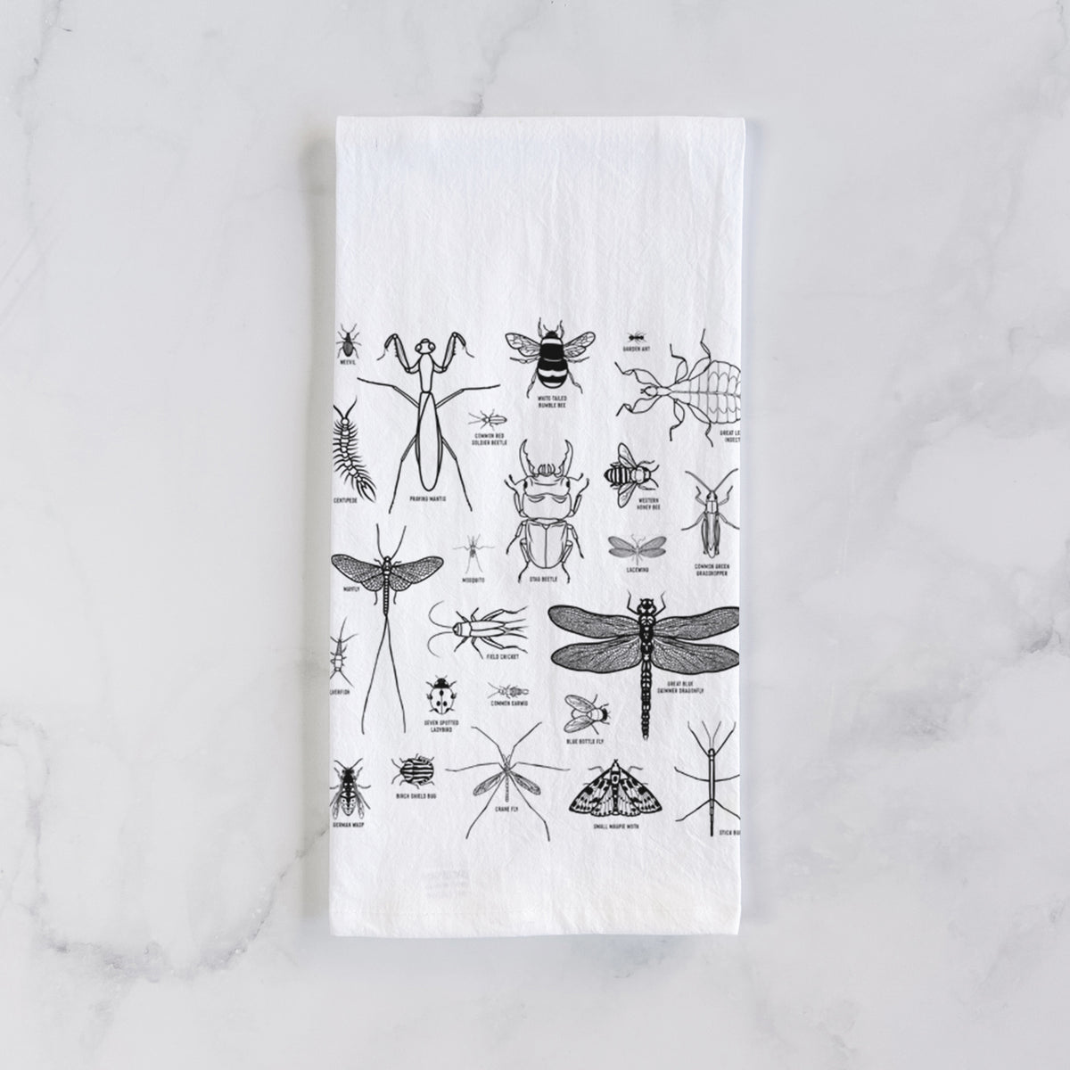 White cotton tea towel laid flat on marble, printed with a chart of black ink insect and arthropod illustrations, including dragonflies, beetles, spiders and bees.