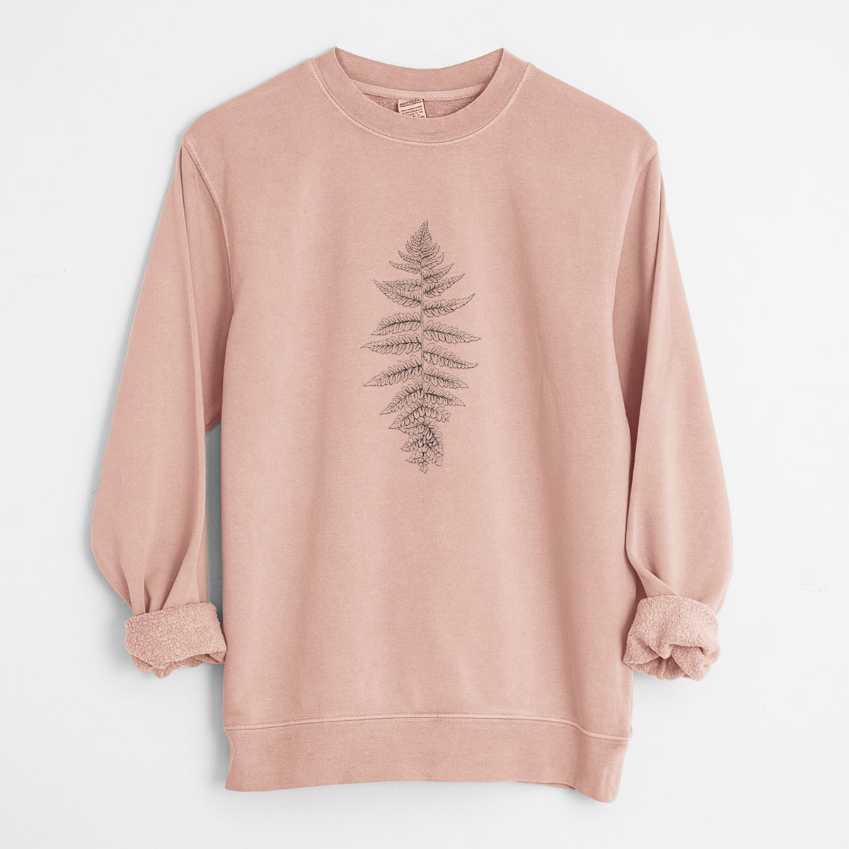 Dusty pink pigment dyed crewneck sweatshirt laid flat with the sleeves rolled, printed with a black ink illustration of a lady fern frond.