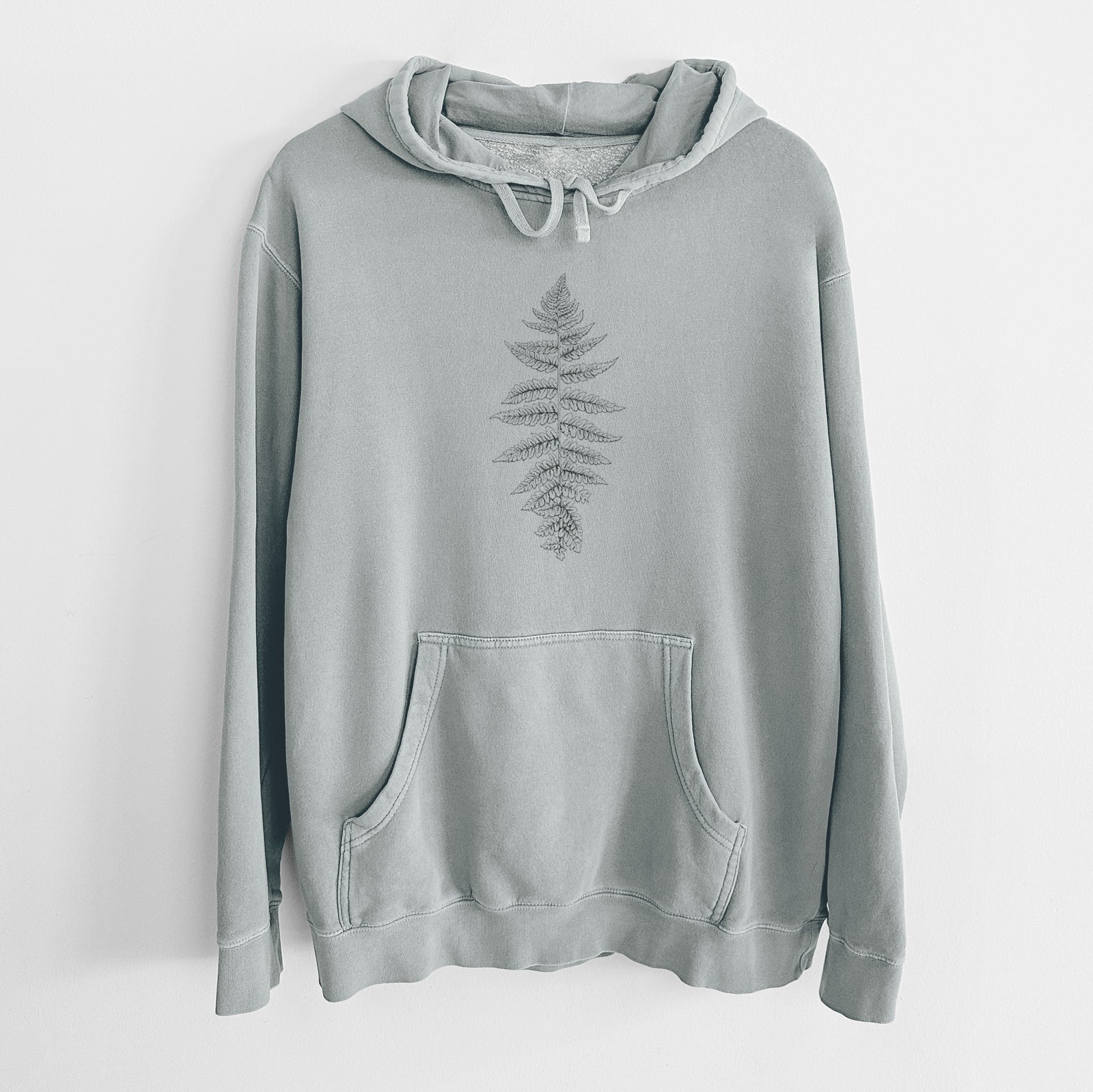 Sage green pigment dyed hoodie laid flat, printed with a black ink illustration of a lady fern frond.