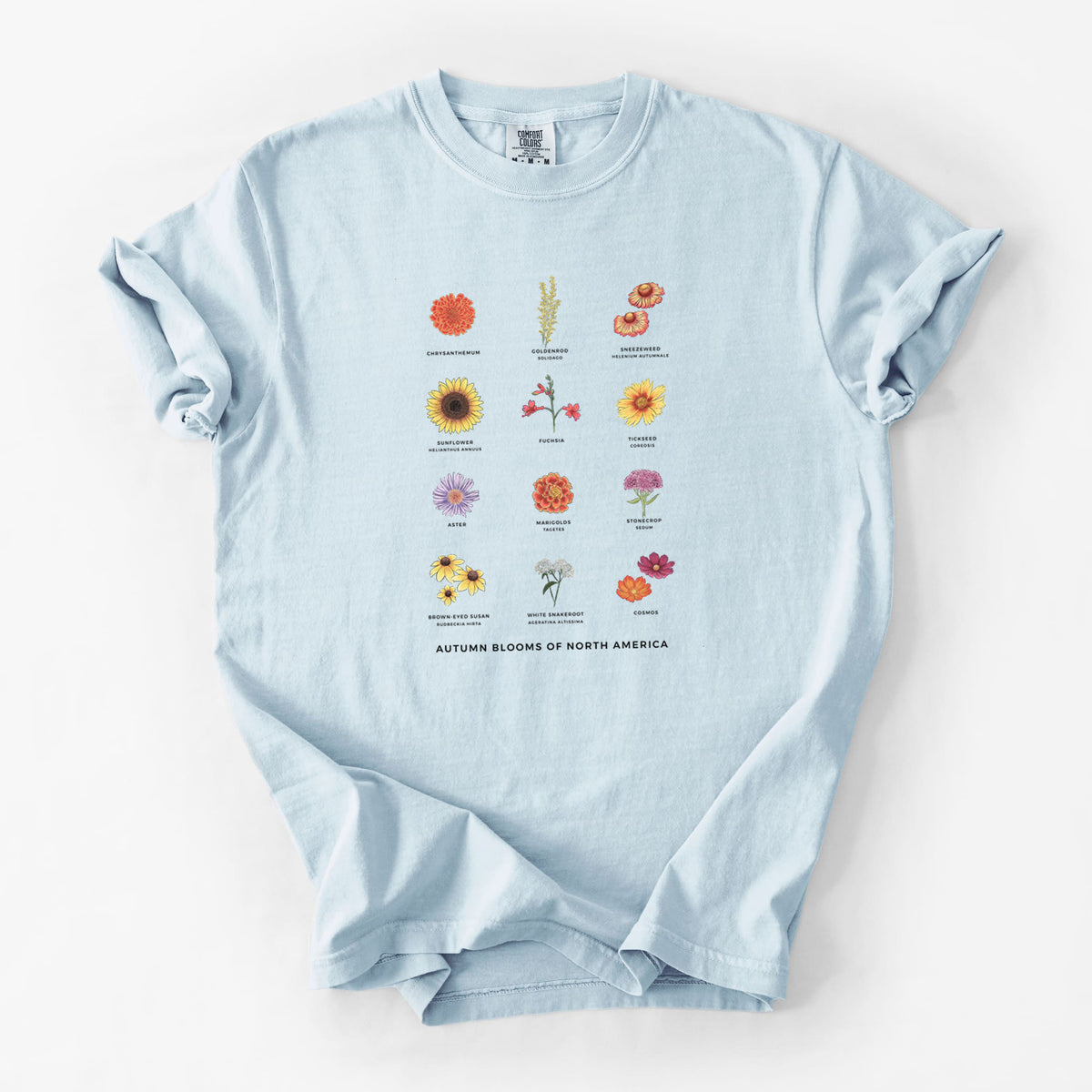 Chambray blue Comfort Colors t-shirt laid flat, printed with a full-color chart of autumn flowers, each labeled with its name.