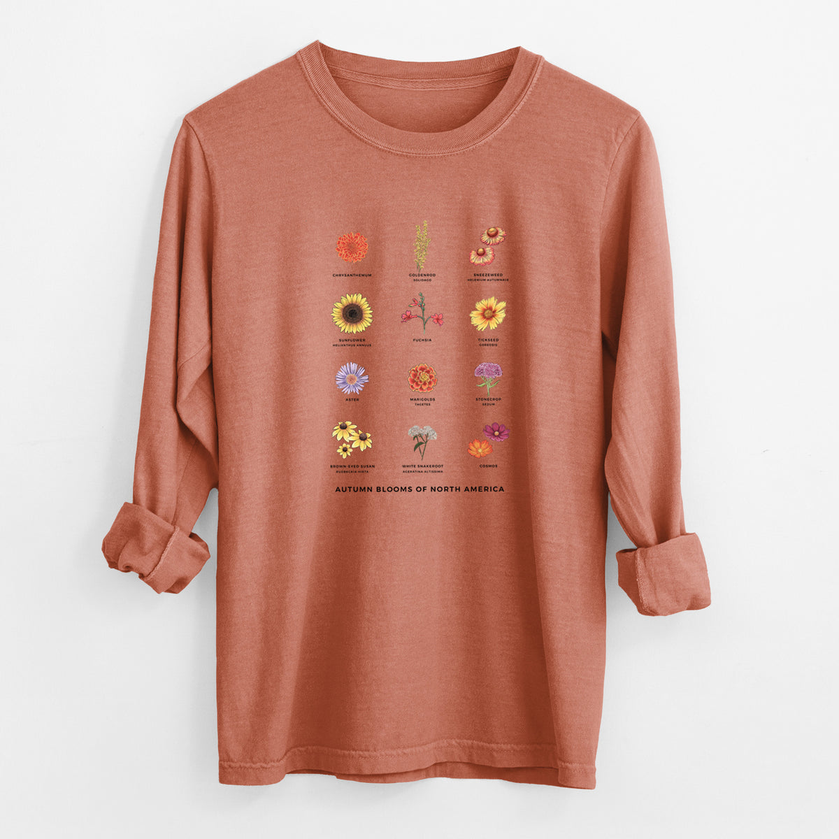 Yam burnt orange Comfort Colors long sleeve shirt laid flat with the cuffs rolled, printed with a full-color chart of autumn flowers, each labeled with its name.