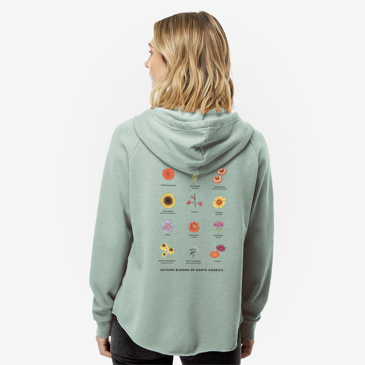 Woman wearing a sage green women's Cali Wave zip-up sweatshirt printed with a full-color chart of autumn flowers, each labeled with its name, seen from behind.