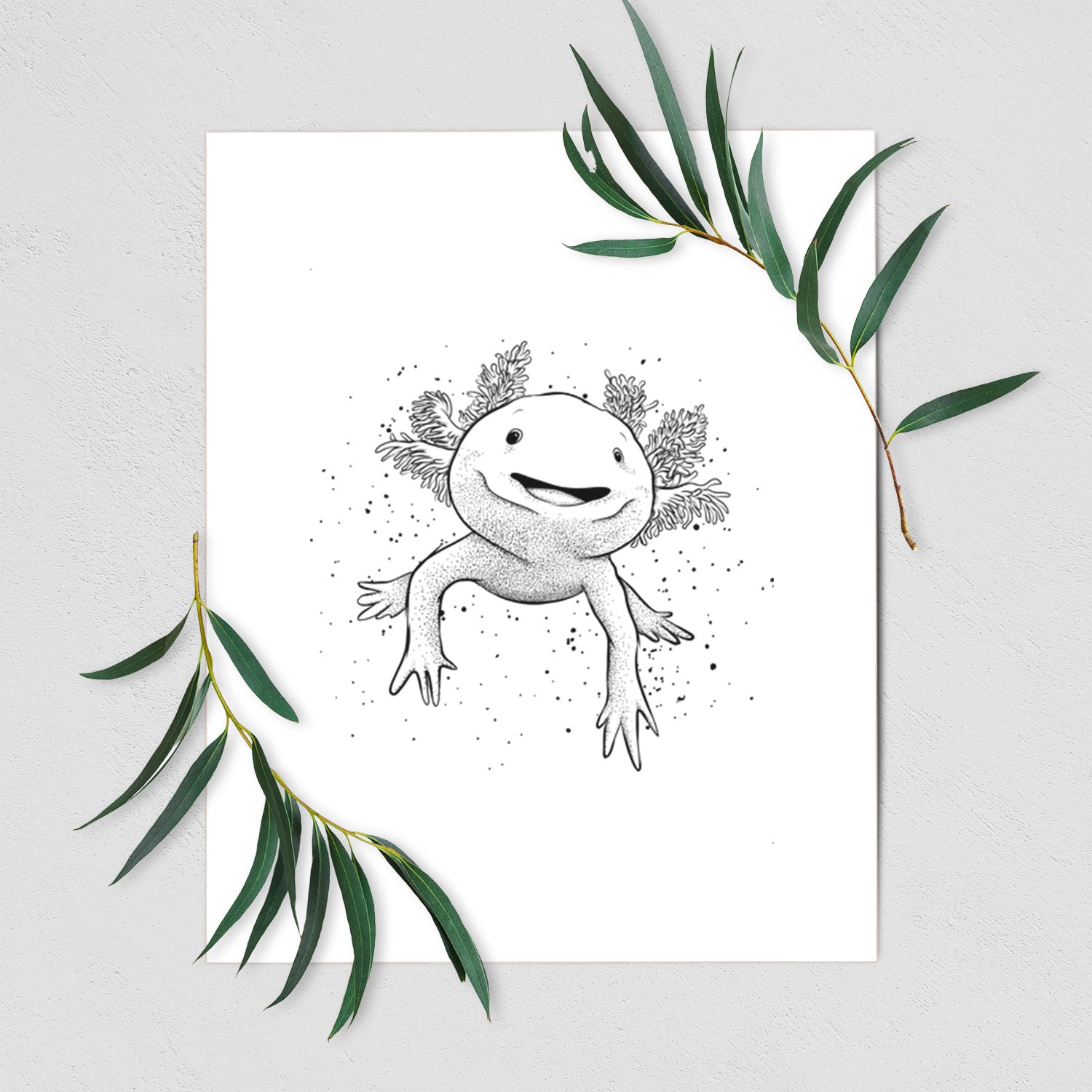 Art print of a black ink illustration of a smiling axolotl with feathery gills, shown with eucalyptus leaves.