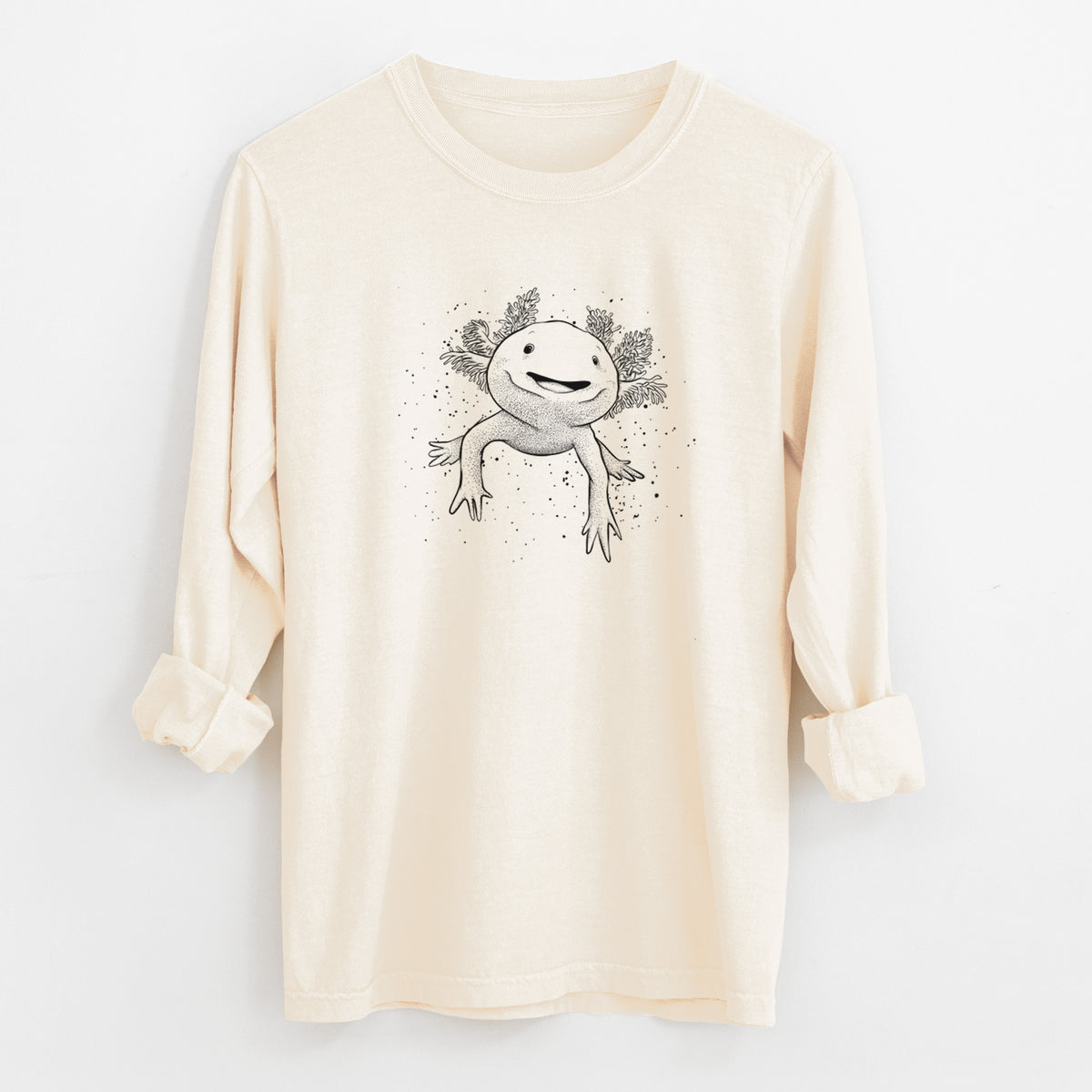 Ivory Comfort Colors long sleeve shirt laid flat with the cuffs rolled, printed with a black ink illustration of a smiling axolotl with feathery gills.