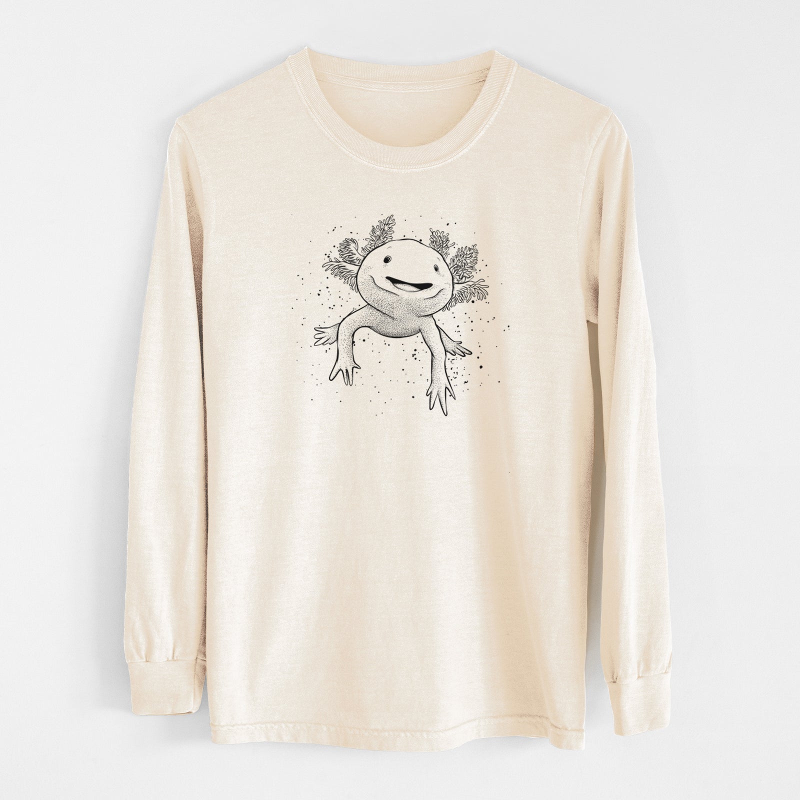 Ivory Comfort Colors long sleeve shirt laid flat, printed with a black ink illustration of a smiling axolotl with feathery gills.