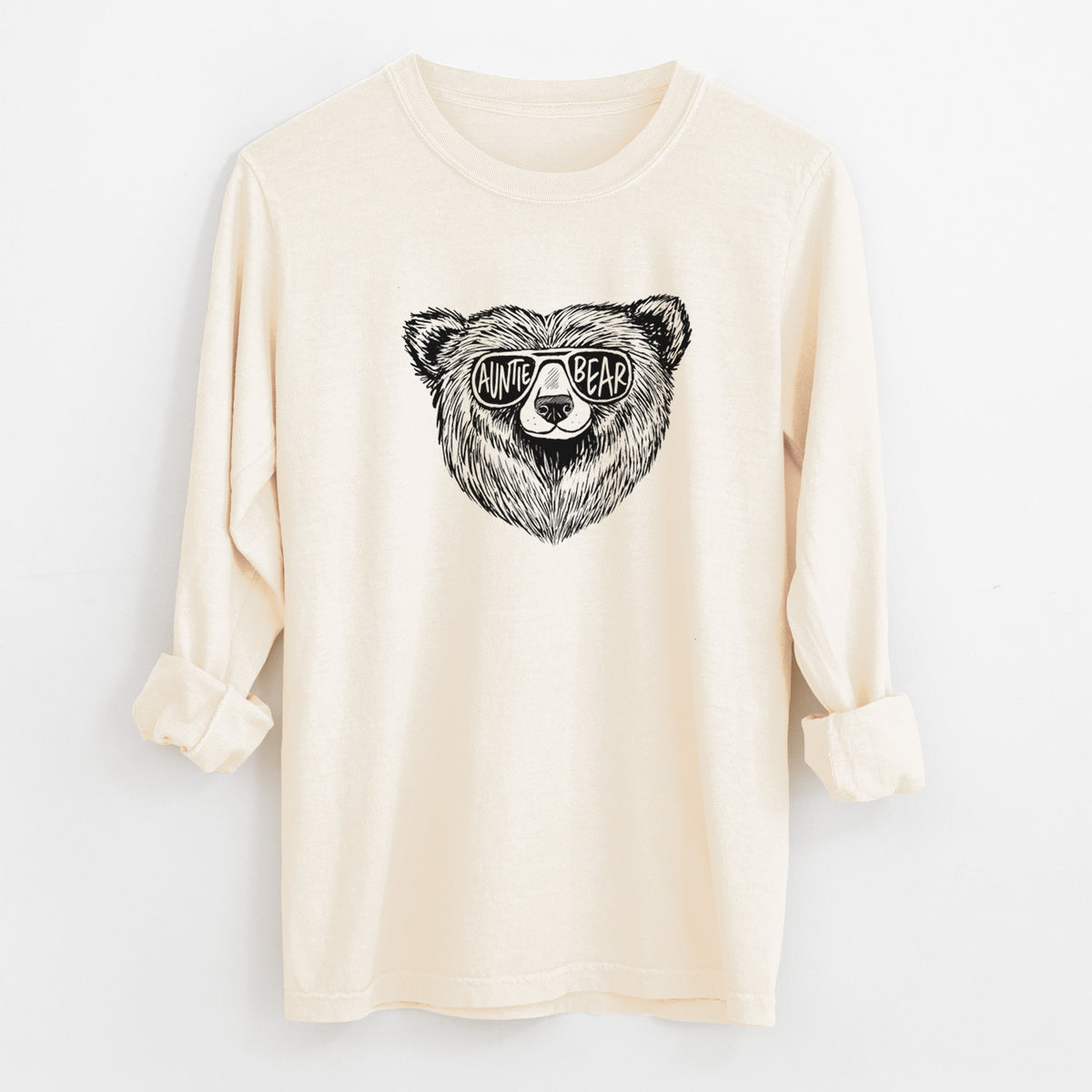 Ivory Comfort Colors long sleeve shirt laid flat with the cuffs rolled, printed with a black ink bear's face wearing sunglasses that read Auntie Bear.