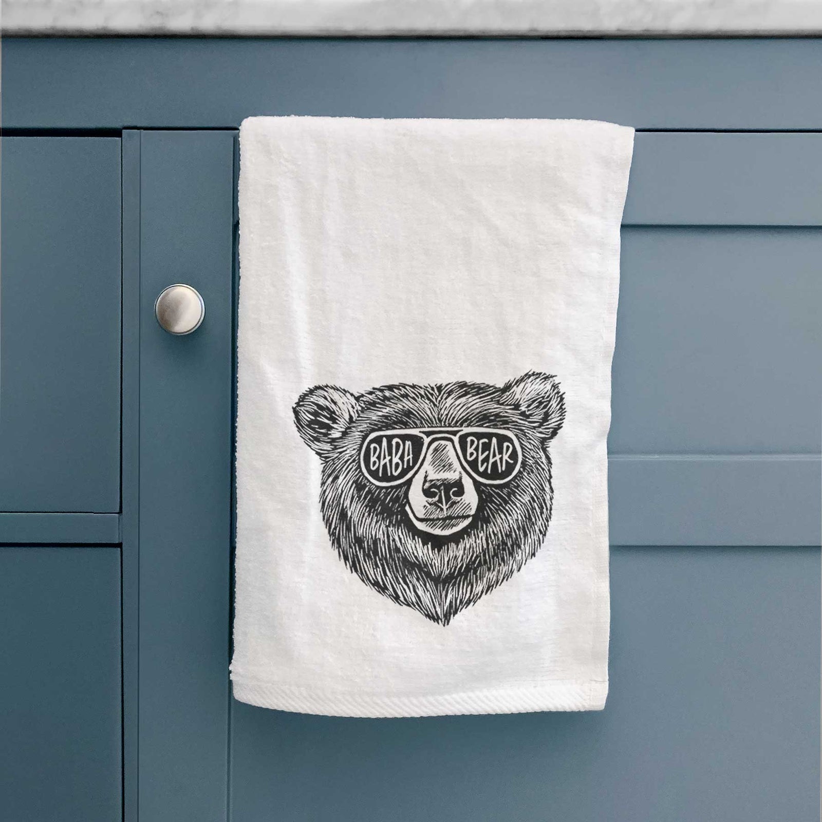 White hand towel printed with a black ink bear's face wearing sunglasses that read Baba Bear.