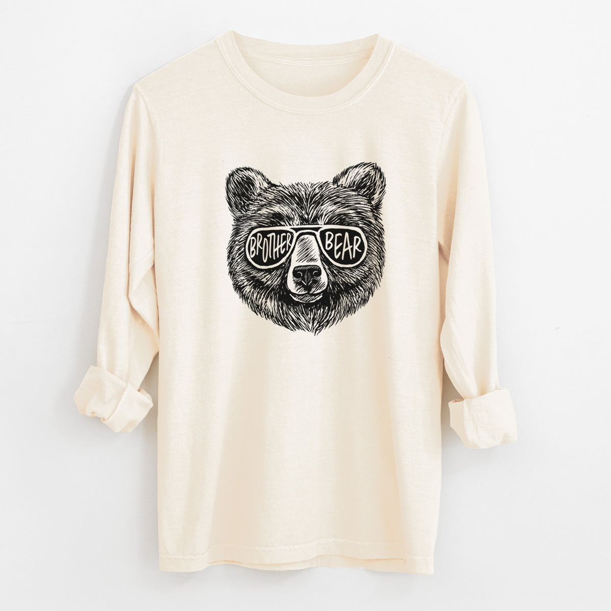 Ivory Comfort Colors long sleeve shirt laid flat with the cuffs rolled, printed with a black ink bear's face wearing sunglasses that read Brother Bear.