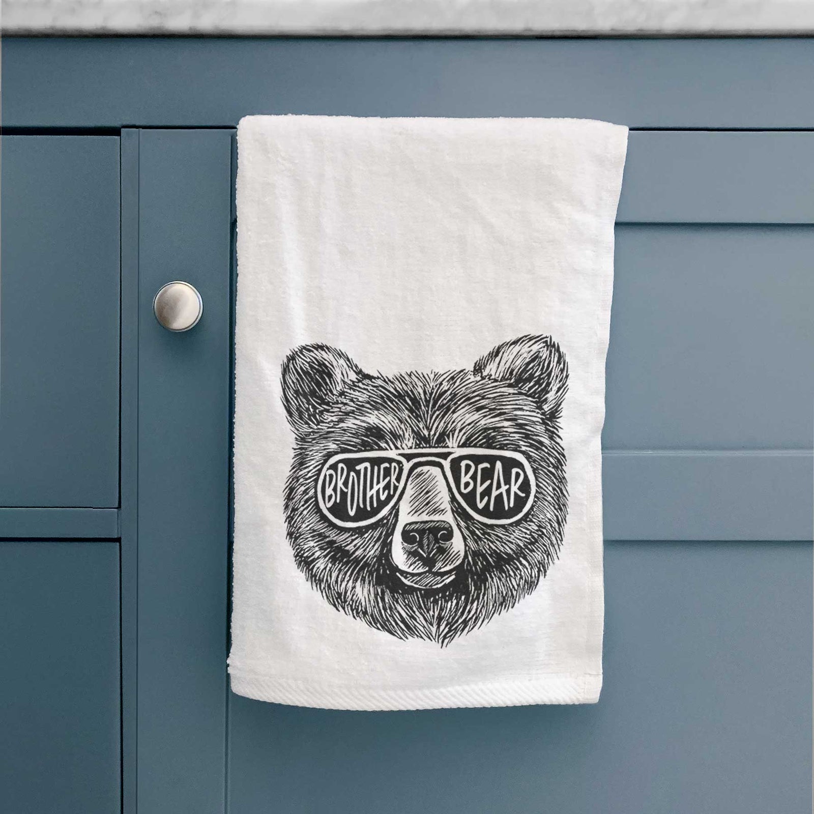 White hand towel printed with a black ink bear's face wearing sunglasses that read Brother Bear.
