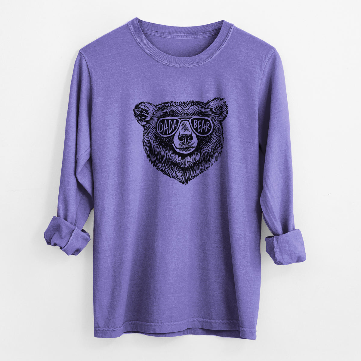Violet purple Comfort Colors long sleeve shirt laid flat with the cuffs rolled, printed with a black ink bear's face wearing sunglasses that read Dada Bear.