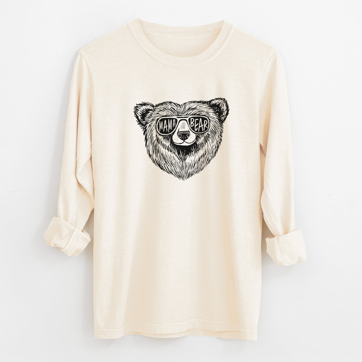 Ivory Comfort Colors long sleeve shirt laid flat with the cuffs rolled, printed with a black ink bear's face wearing sunglasses that read Mama Bear.