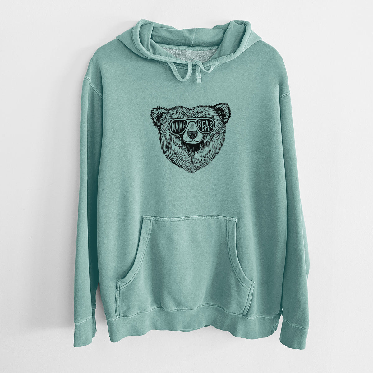 Mint green pigment dyed hoodie laid flat, printed with a black ink bear's face wearing sunglasses that read Mama Bear.
