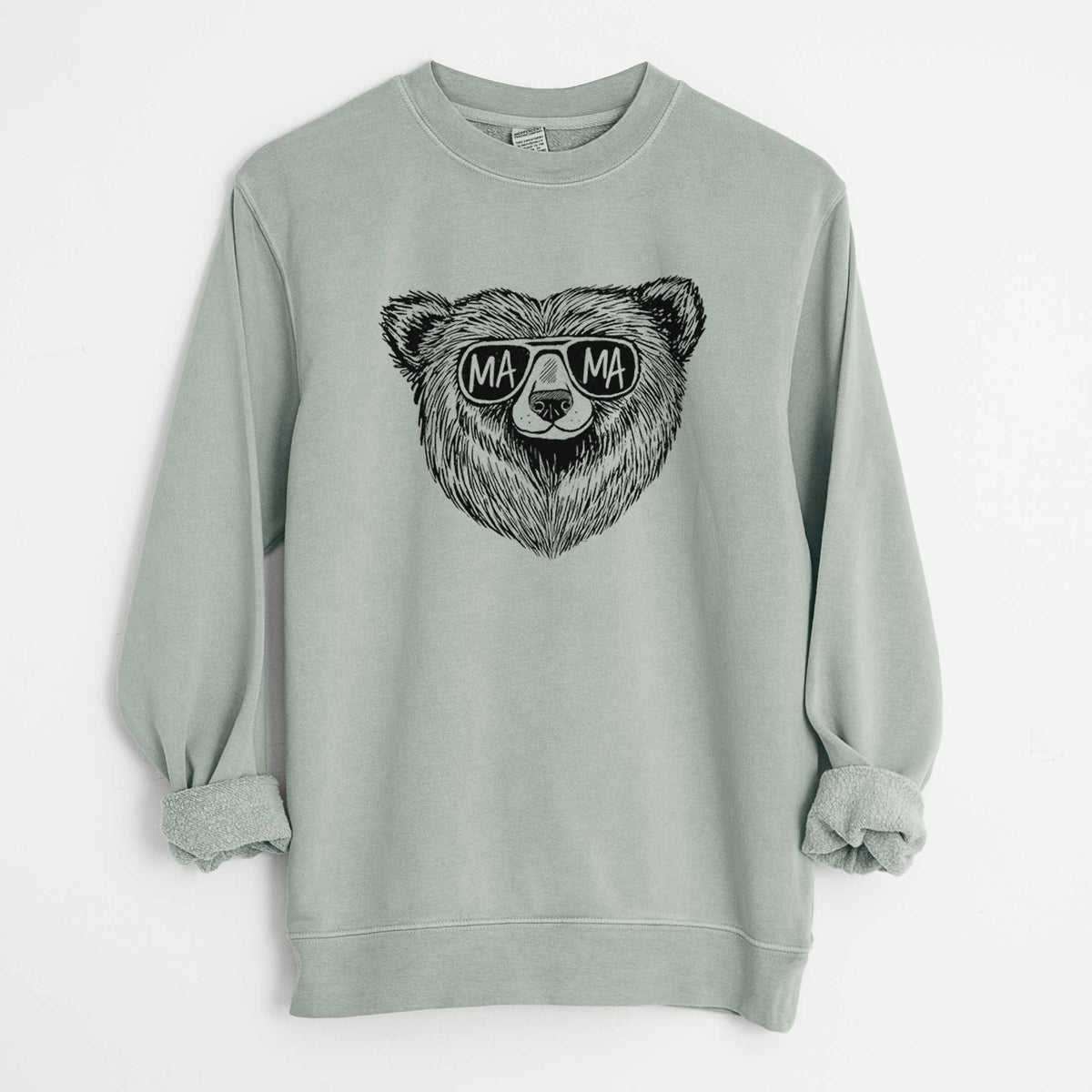 Sage green pigment dyed crewneck sweatshirt laid flat with the sleeves rolled, printed with a black ink bear's face wearing sunglasses that read Mama.